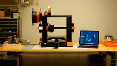 3D tiskárna a notebook na pracovním stole v dílně